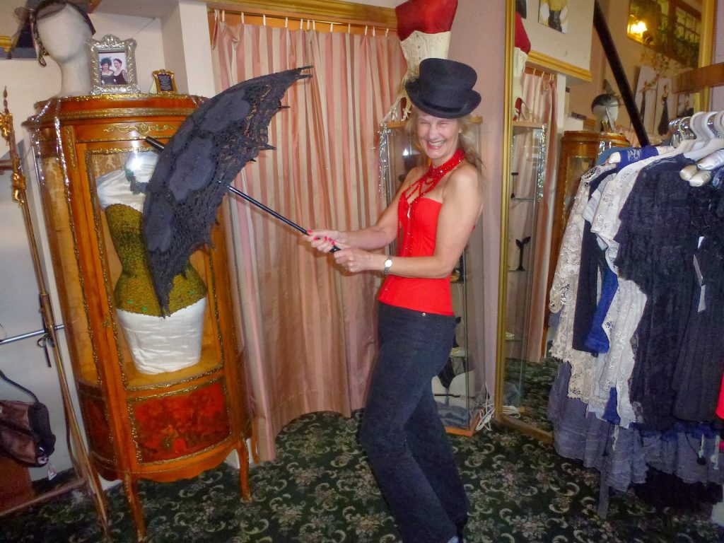 laughing wearing a sweetheart corset, parasol and tophat